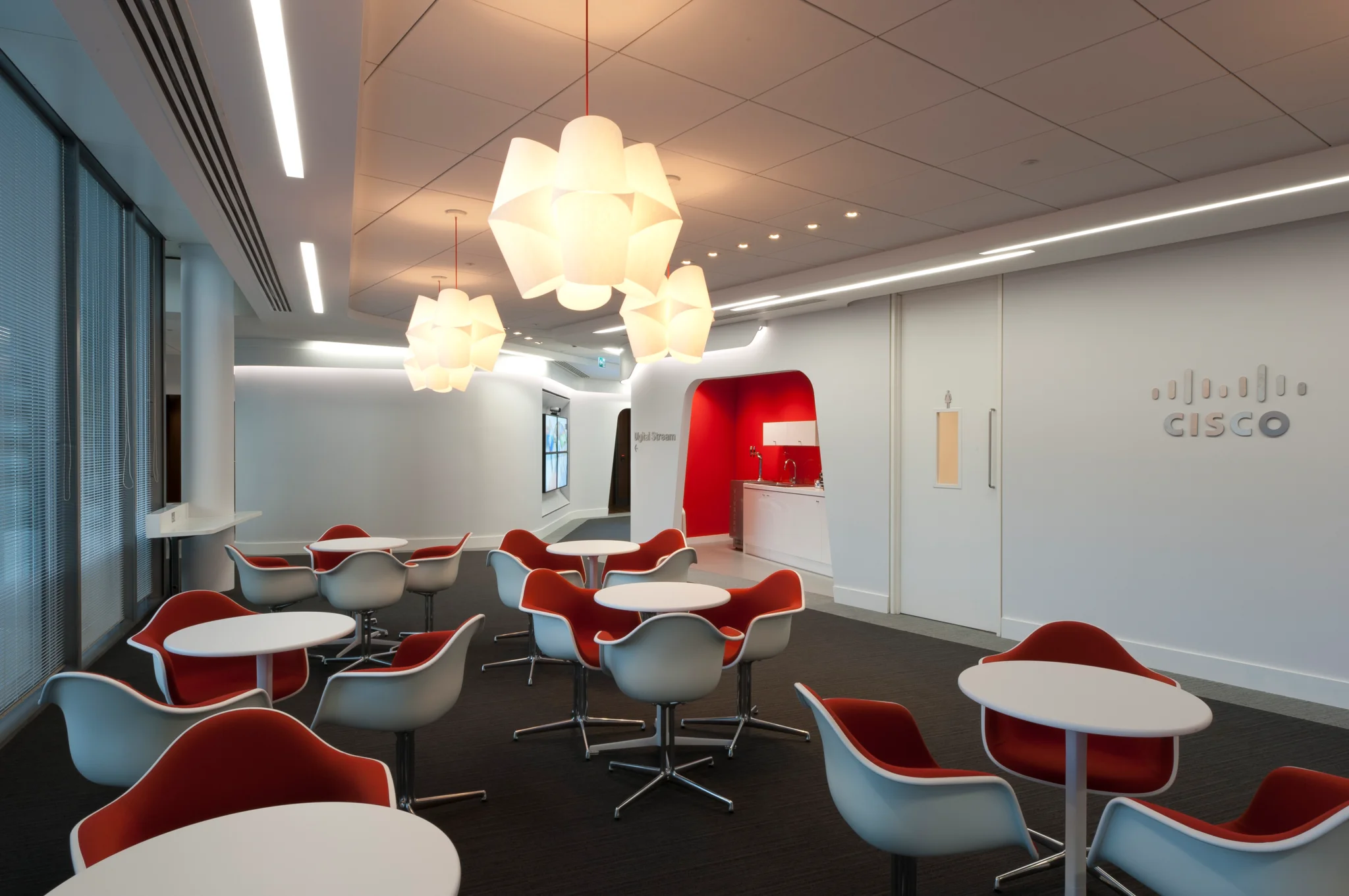 red chairs around small white cafe tables with cream pendant lighting