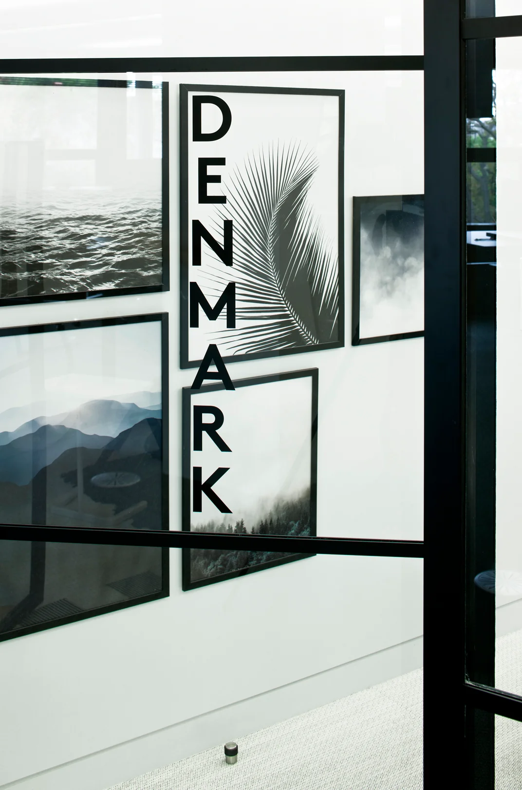 denmark sign on board room glass door with scenic prints on the wall behind
