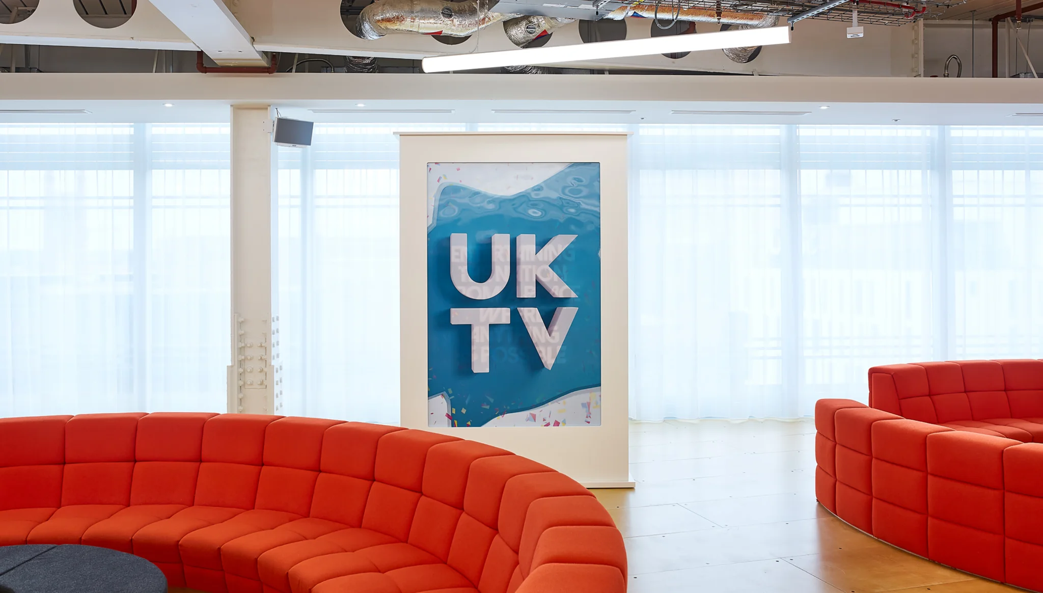 uktv logo sign between two red circle sofas