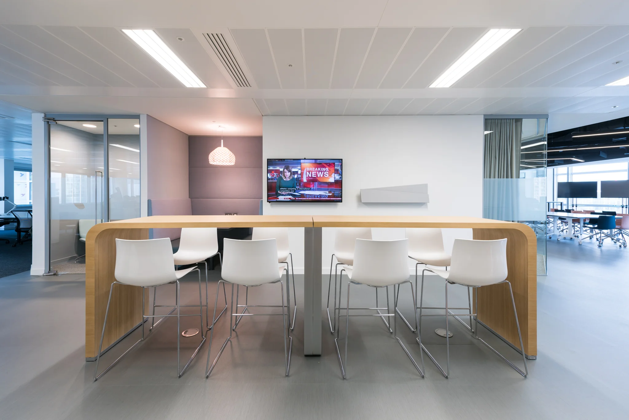 long curved breakfast bar table with white bar stools around it