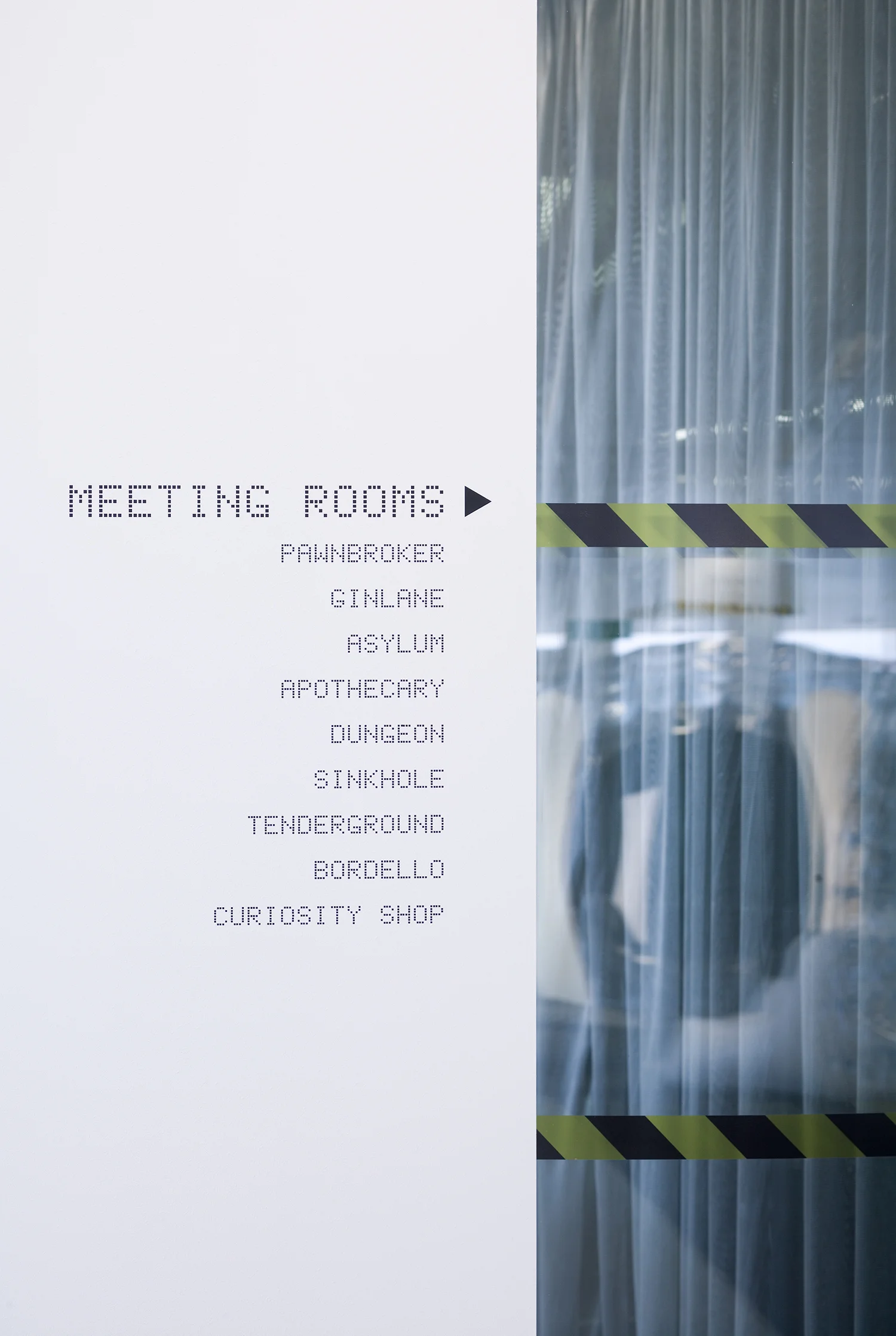 wall with list of quirky meeting room names on it