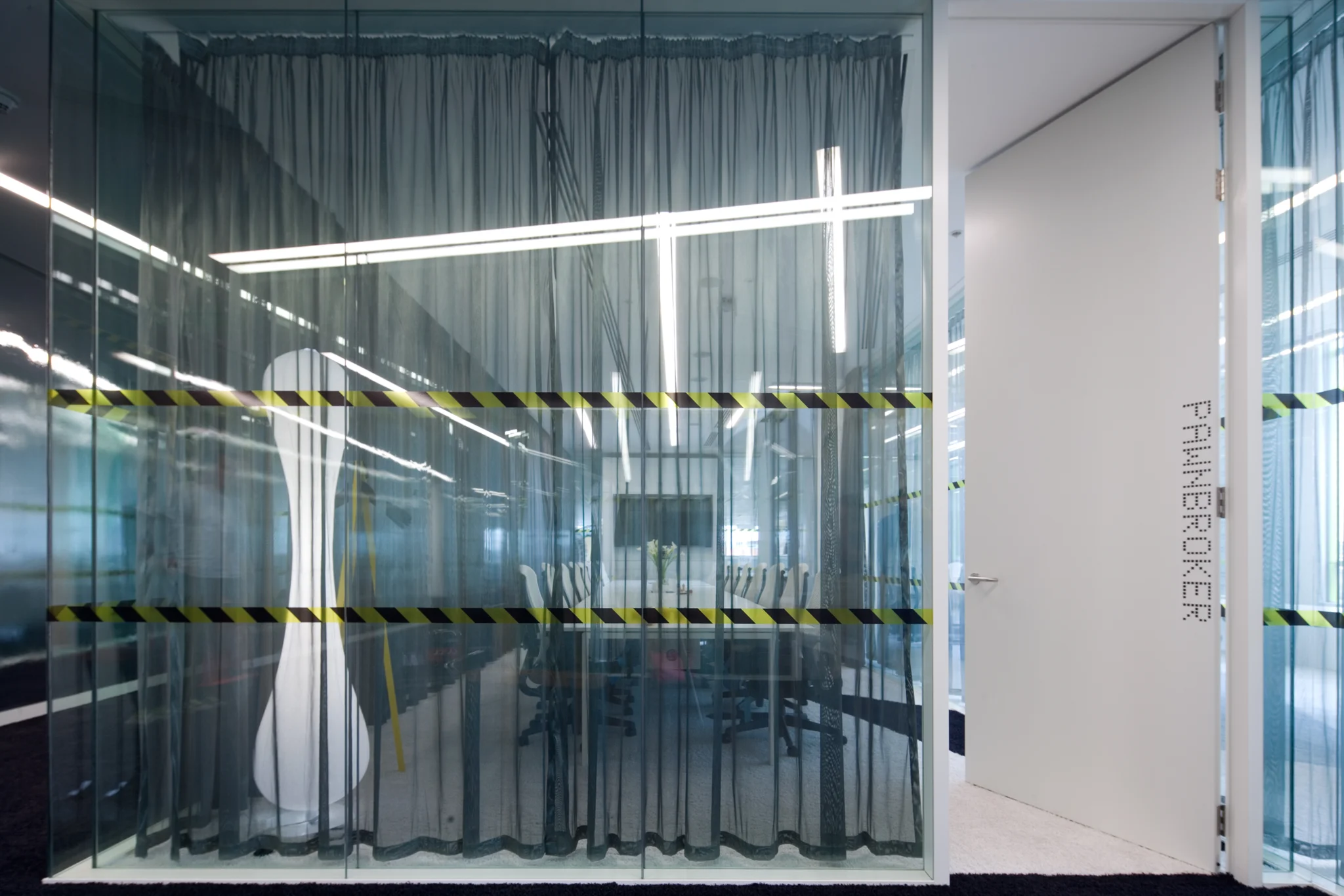 Meeting room with inflatable light, grey mesh curtains & an array of LED linear lights