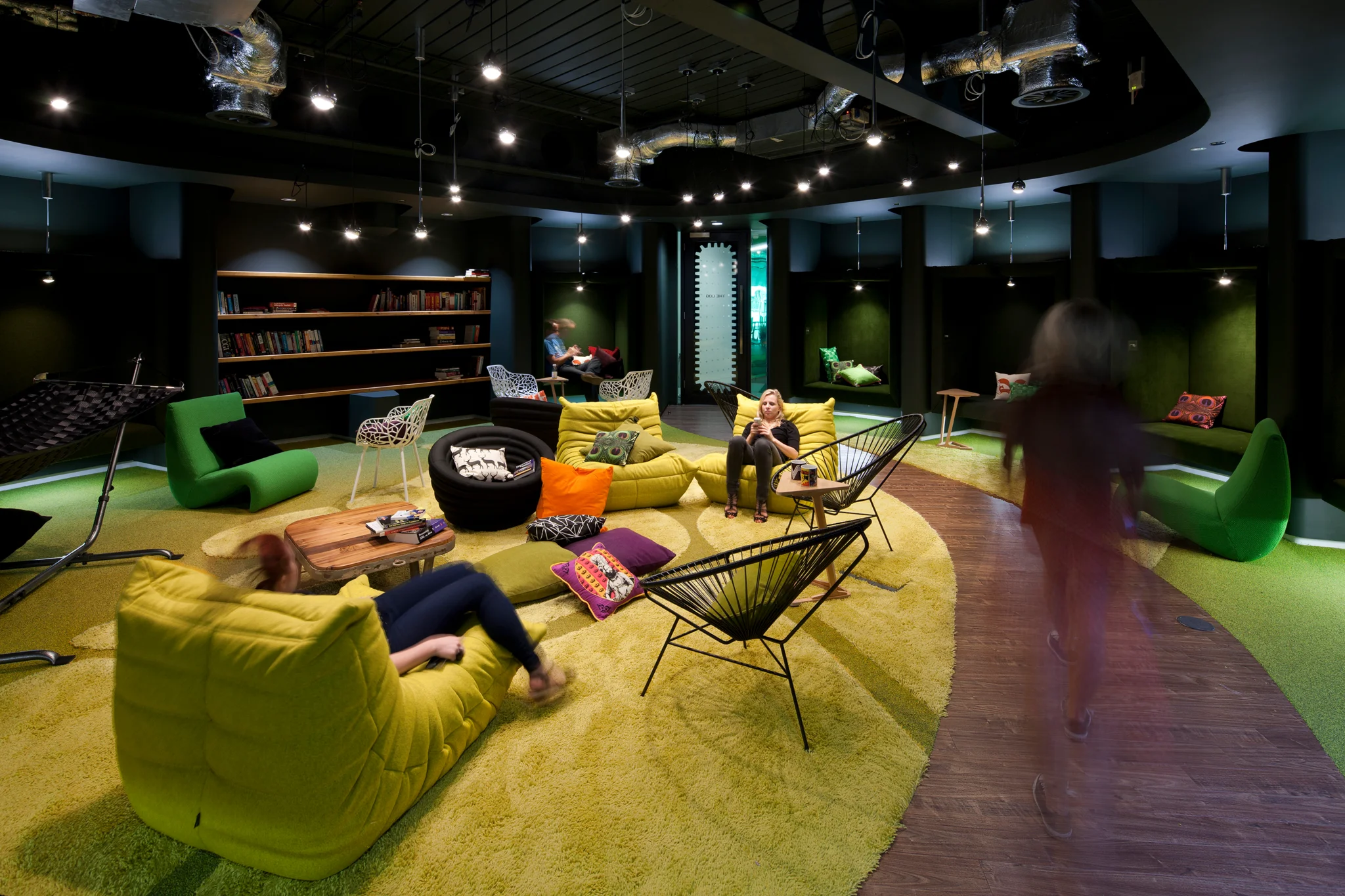 Google cosy lounge with green carpet, dark nooks, eclectic furniture & cushions