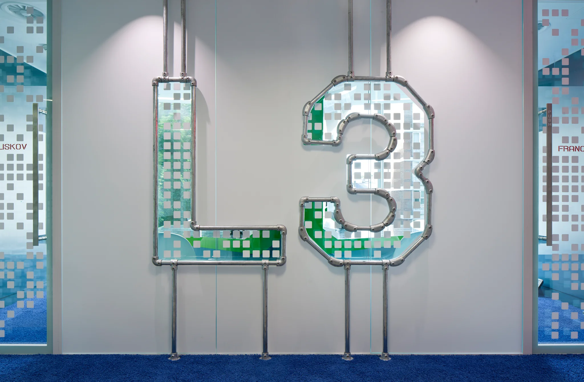 L3 sign on a grey wall with metal pipe outlines