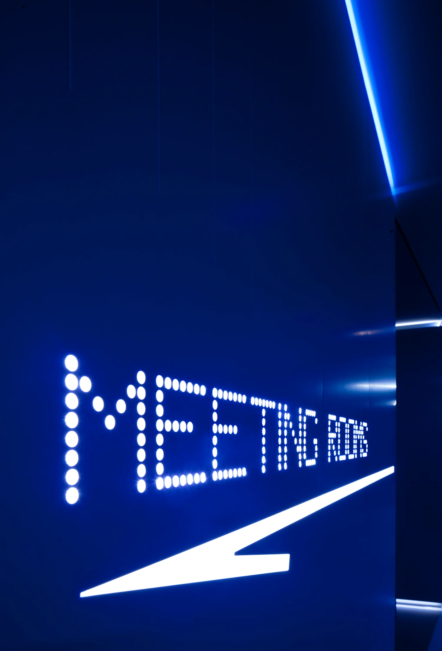 white led light sign reading 'meeting room' on a dark blue background