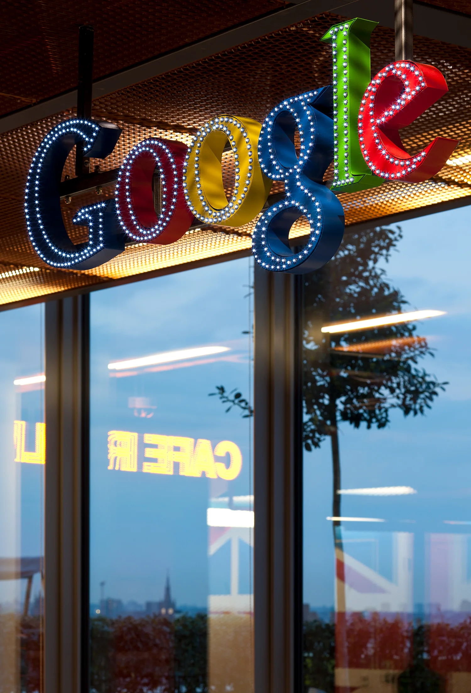Google logo sign above a window reflecting the London skyline