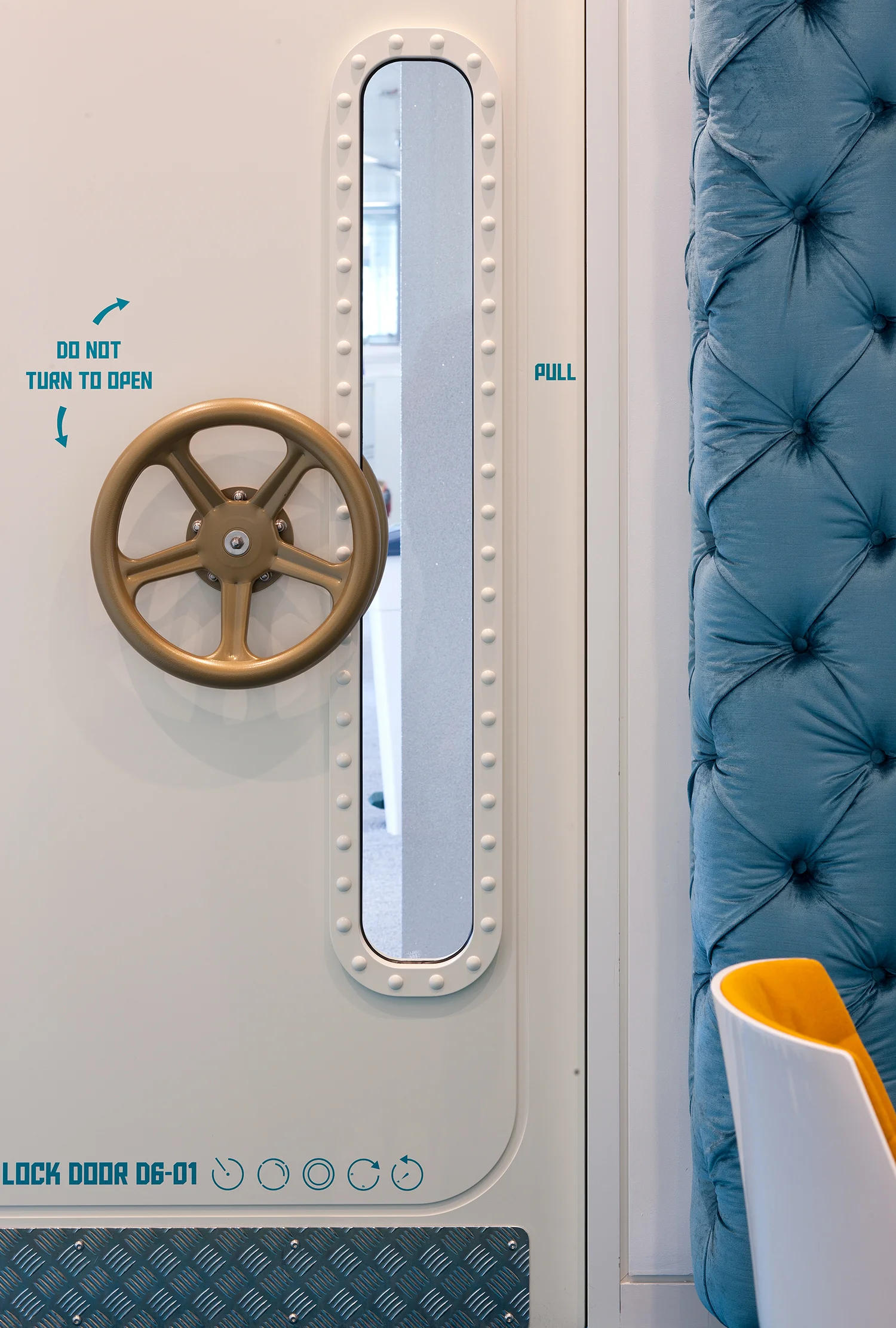 submarine style door with blue stitching details to the right of the door