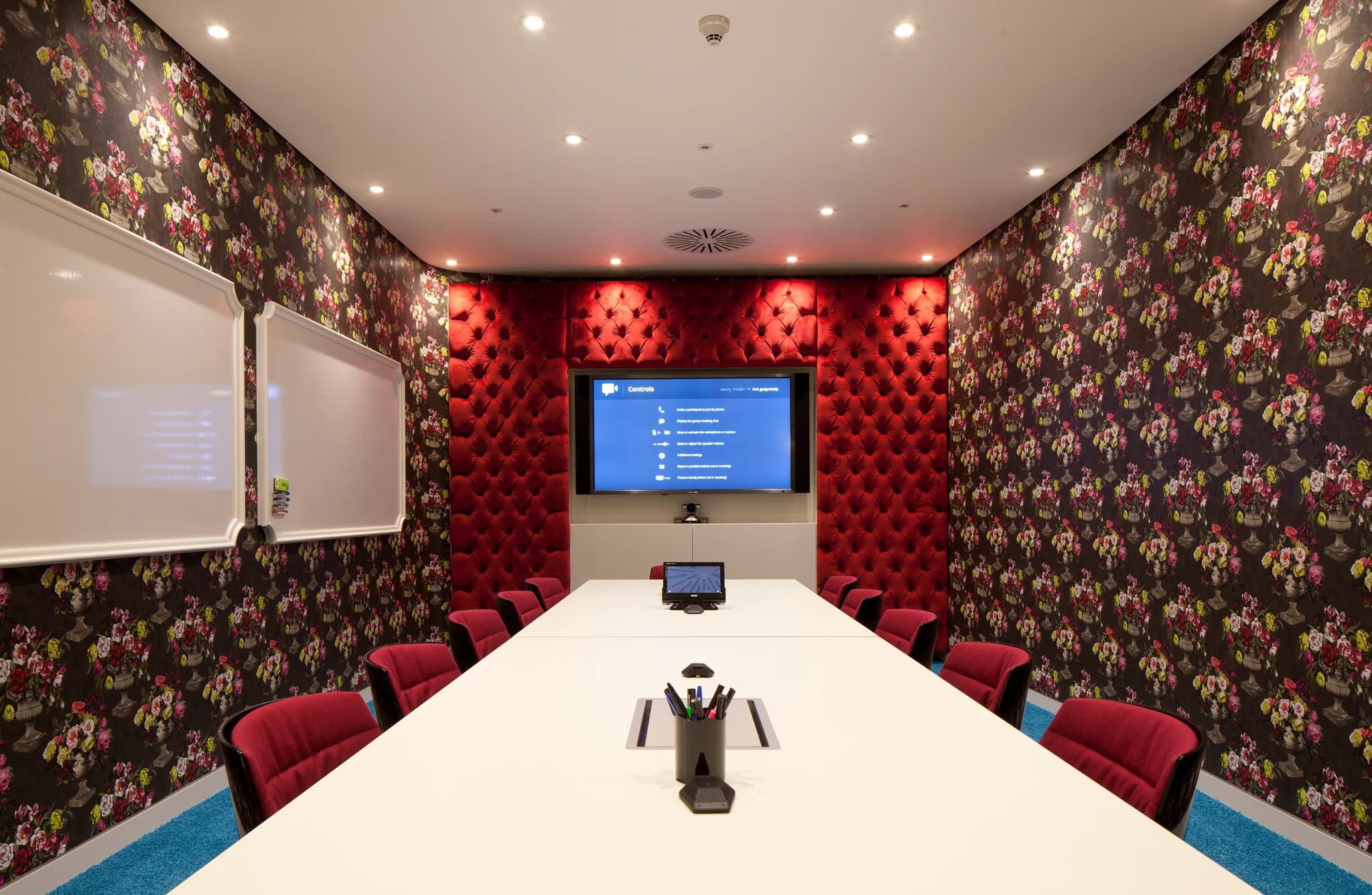 meeting room with floral wallpaper and a screen on the far wall