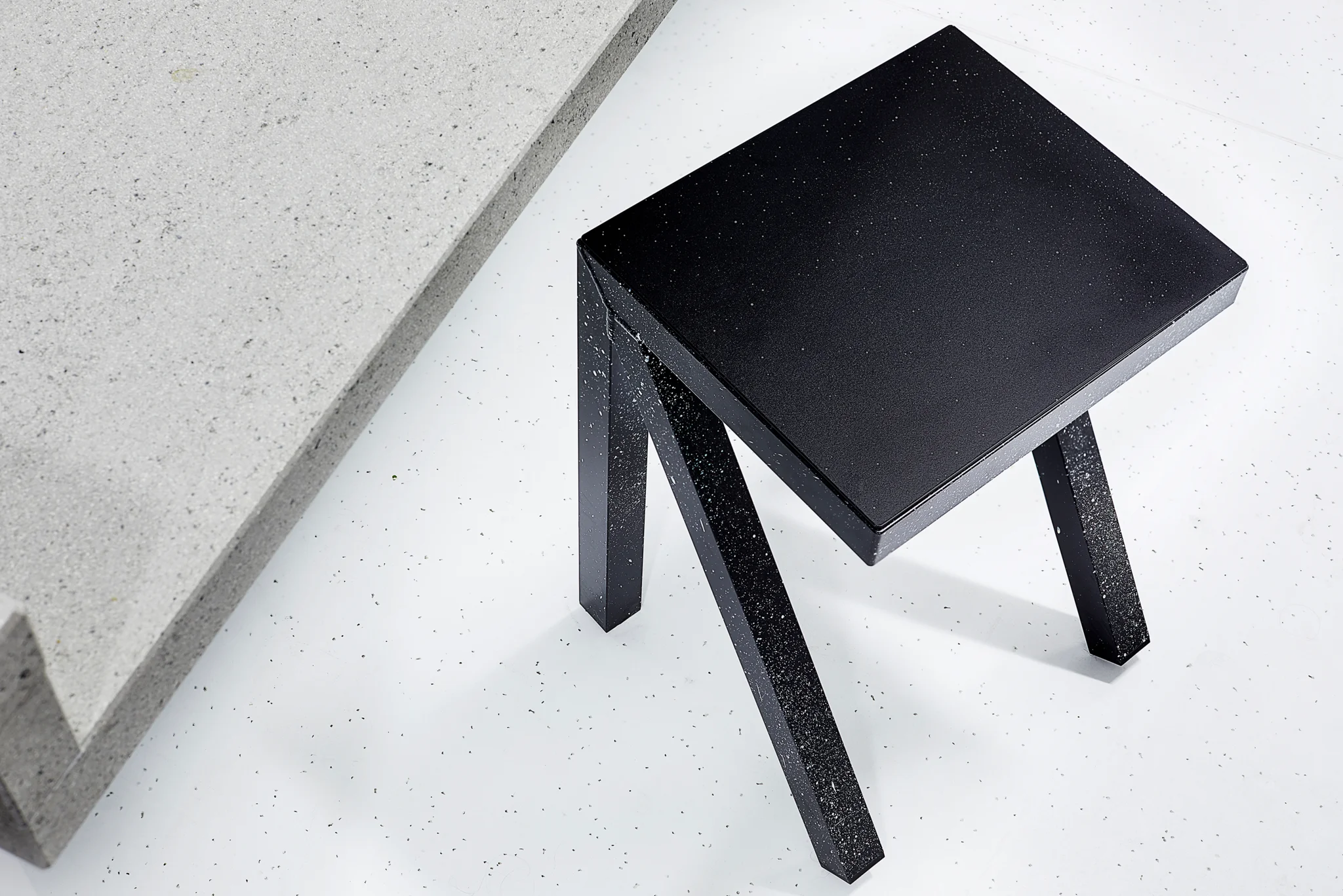 Black speckled architectural-style low stool