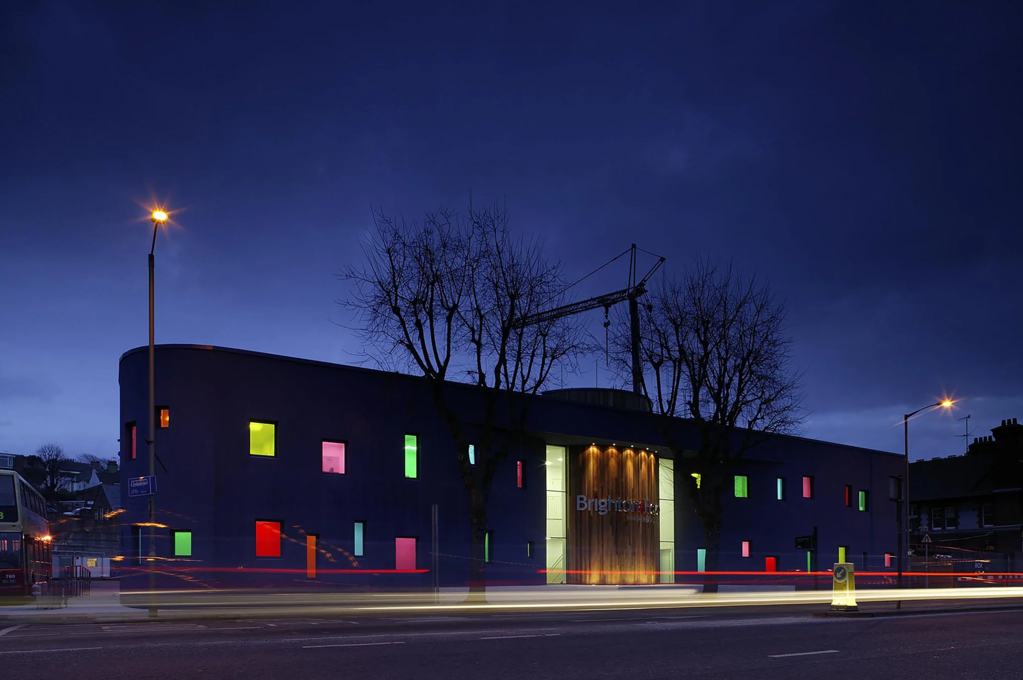 Night image of Brighton Goahead exterior front facade with coloured windows and logo sign