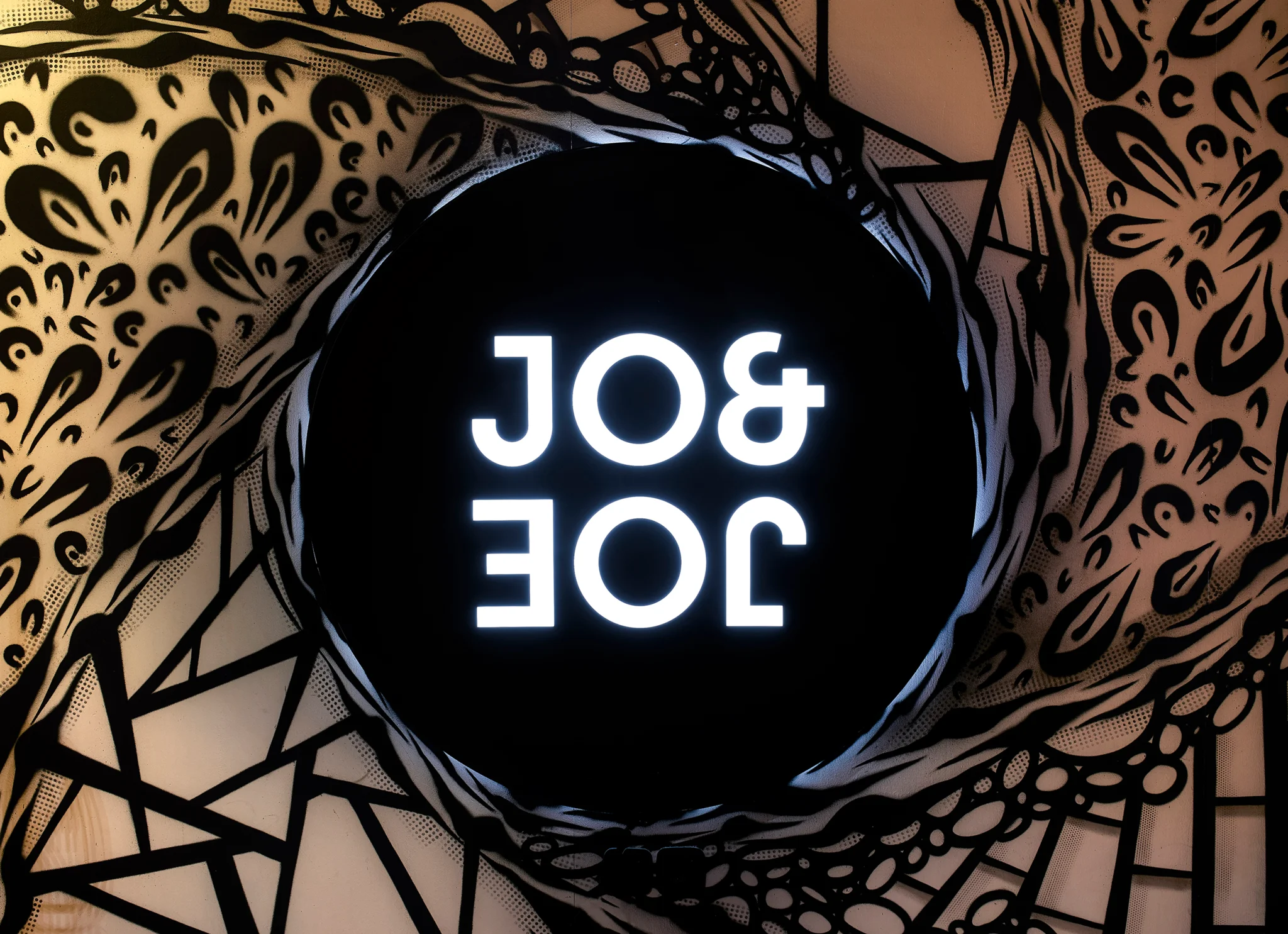 在黑白涂鸦墙的衬托下,JO&JOE的黑白标志。