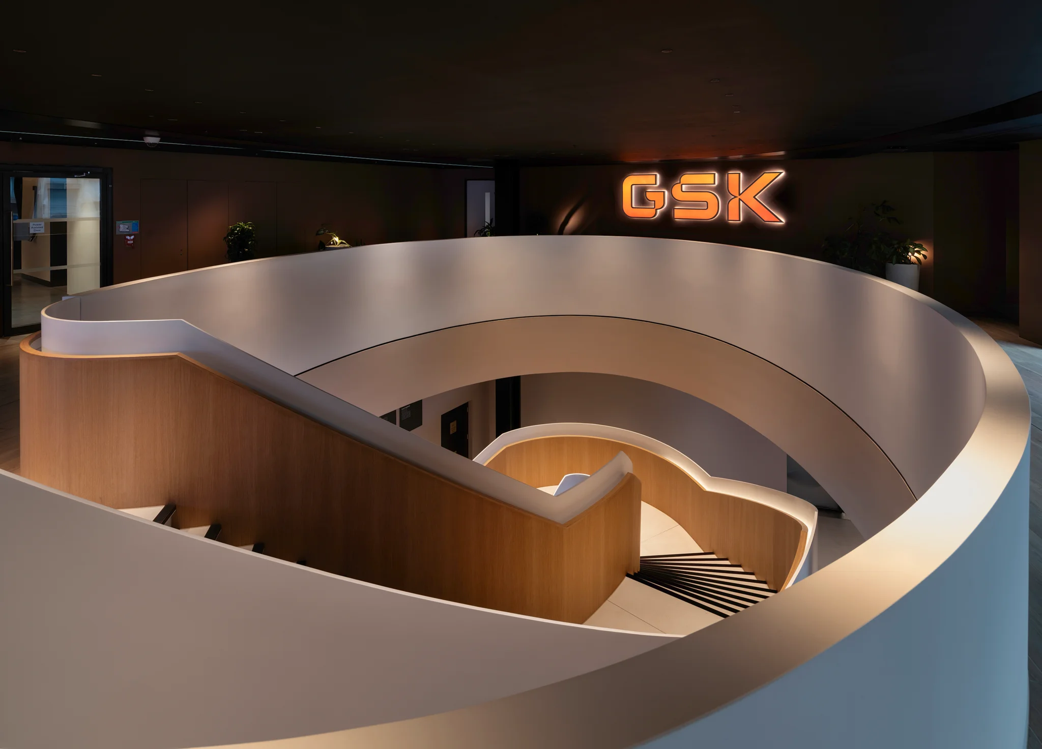 Curved architectural staircase and GSK branding within the headquarters
