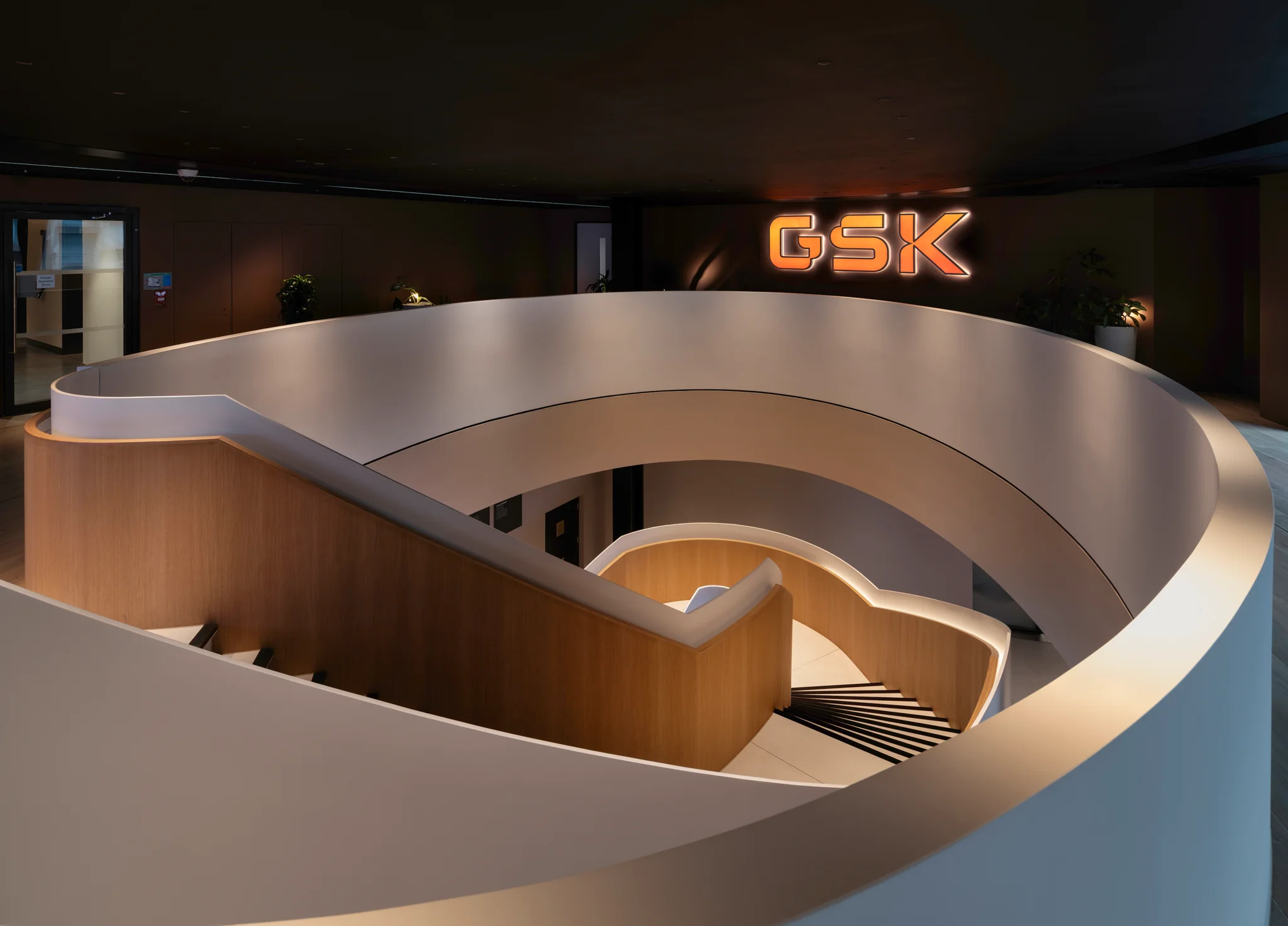 Curved architectural staircase and GSK branding at the company's London headquarters
